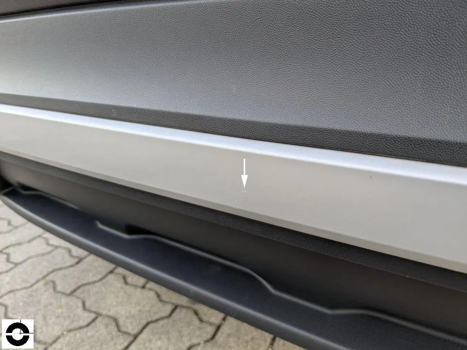 Detailaufnahme einer hinteren Stoßstange mit Markierungspfeil auf dem Schaden