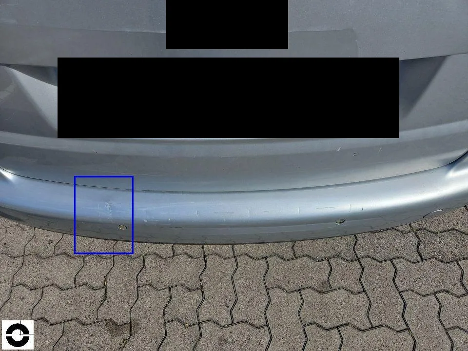 Rear of a silver VW Touran, a blue frame marks older scratch and dent damage on the rear bumper, licence plate redacted
