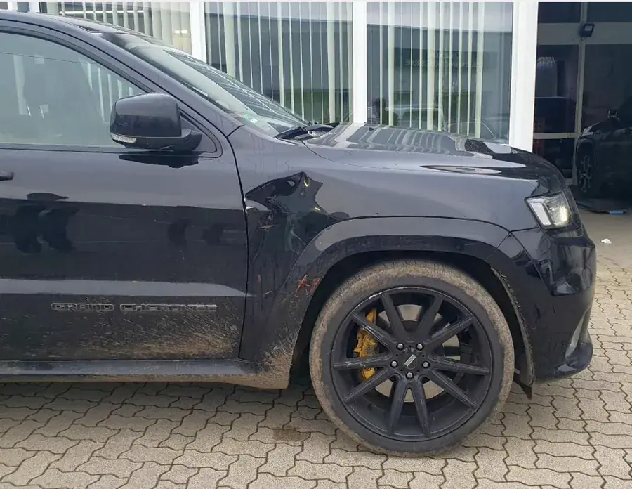 Тёмный внедорожник (Jeep Grand Cherokee) с повреждениями передней части и диска