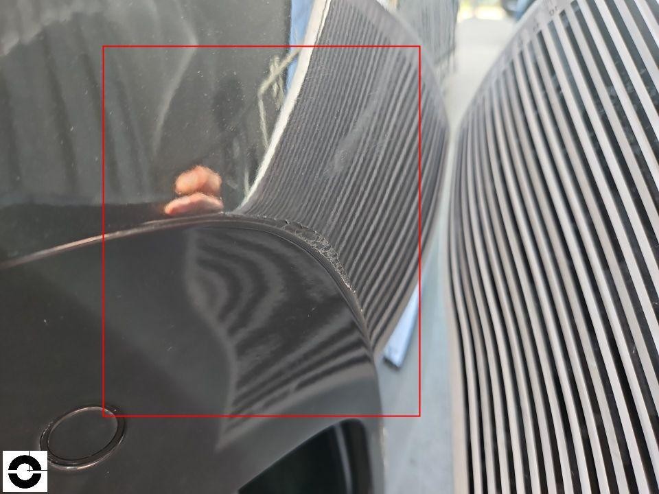 Detailaufnahme Motorhaube vorne rechts, Lackschaden und Kratzer am Übergang zum Kühlergrill