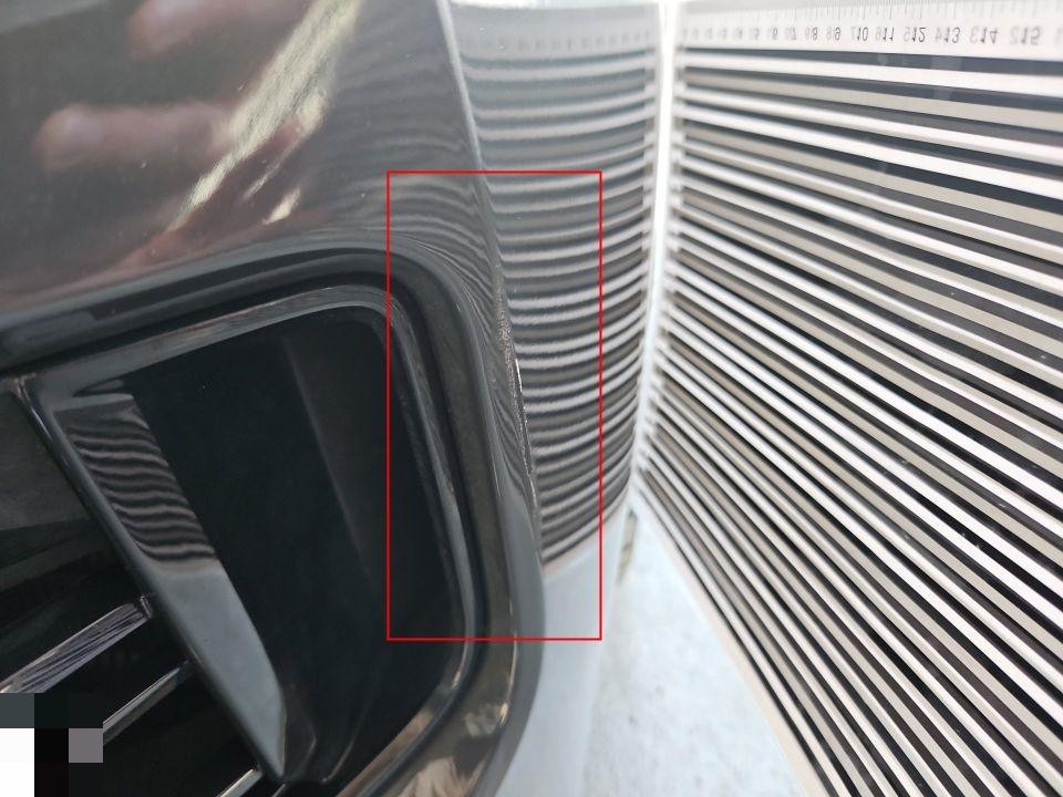 Nahaufnahme Frontgrill mit Verformung, rot markierter Schadensbereich, Maßstab sichtbar