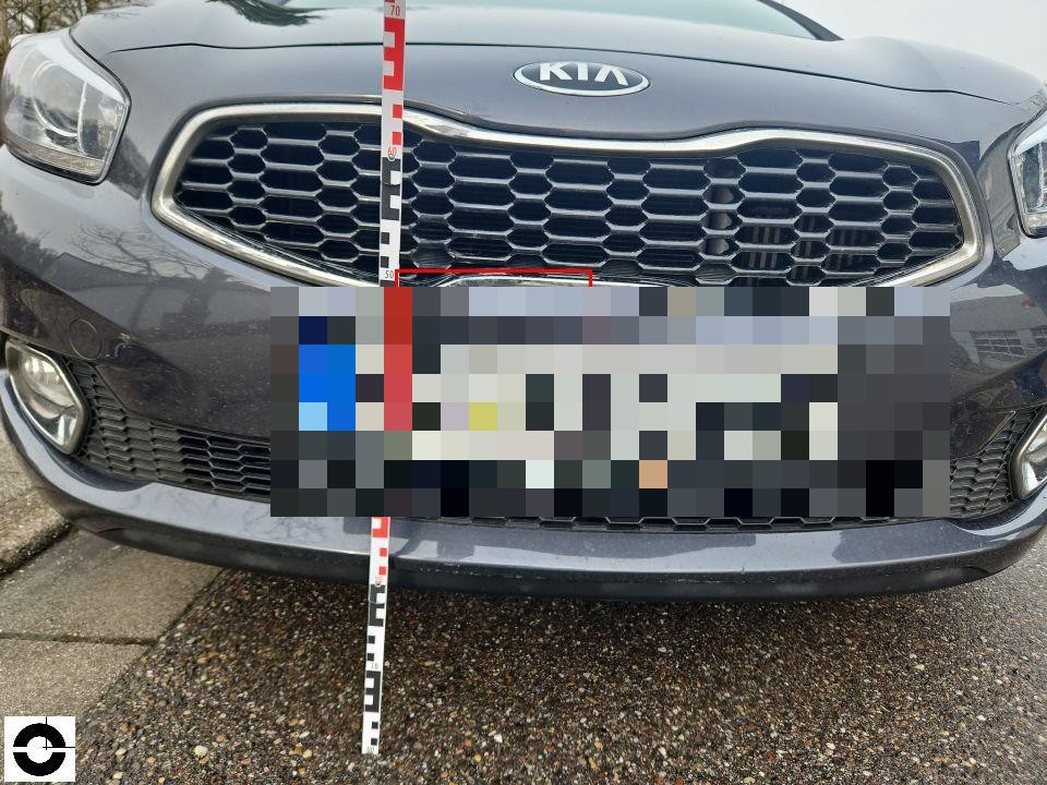 Frontansicht mit Kühlergrill, Kennzeichen pixeliert, Messlatte zur Höhenmessung