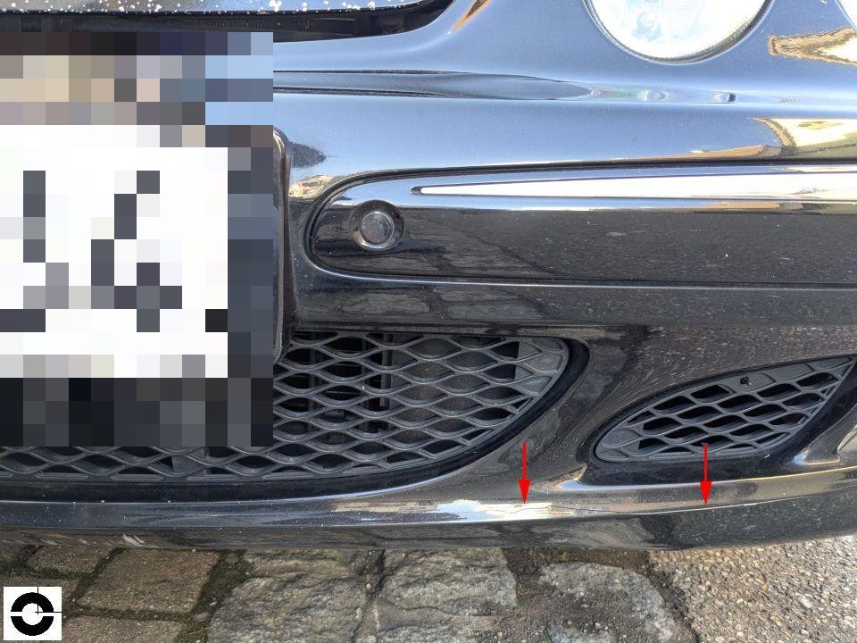 Frontstoßstange unten, rote Pfeile markieren Kratzer an Chromleiste