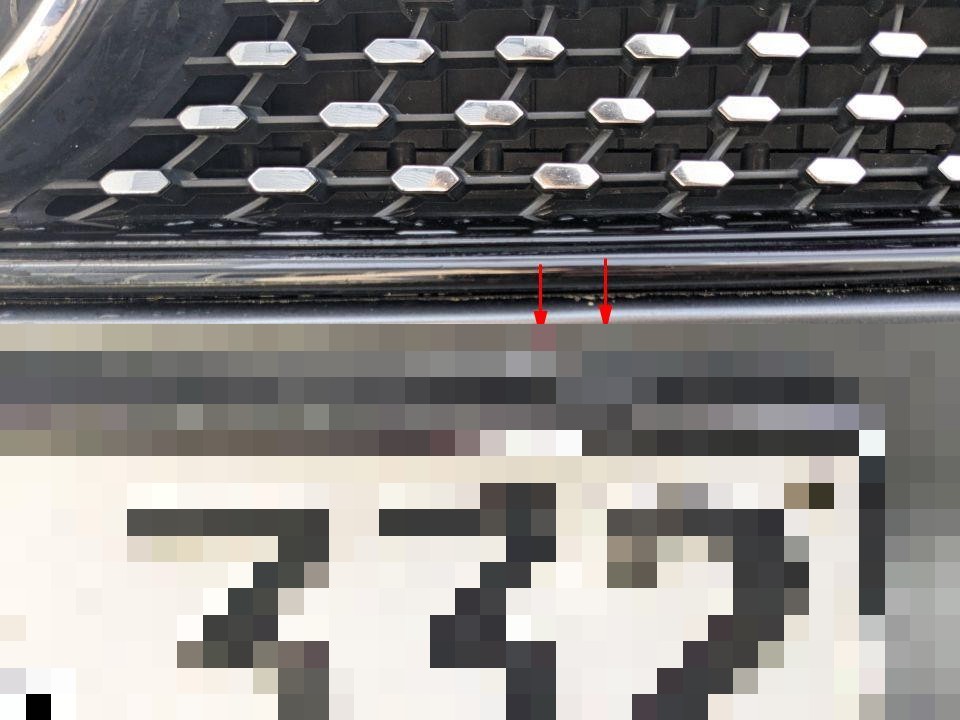 Frontpartie, Kühlergrill mit Wabenmuster, rote Pfeile markieren Kratzer an Chromleiste