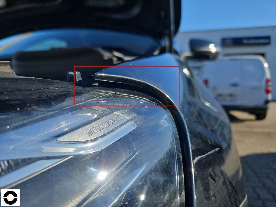Detailaufnahme Scheinwerfer vorne links mit Kratzer auf Abdeckung, roter Markierungsrahmen