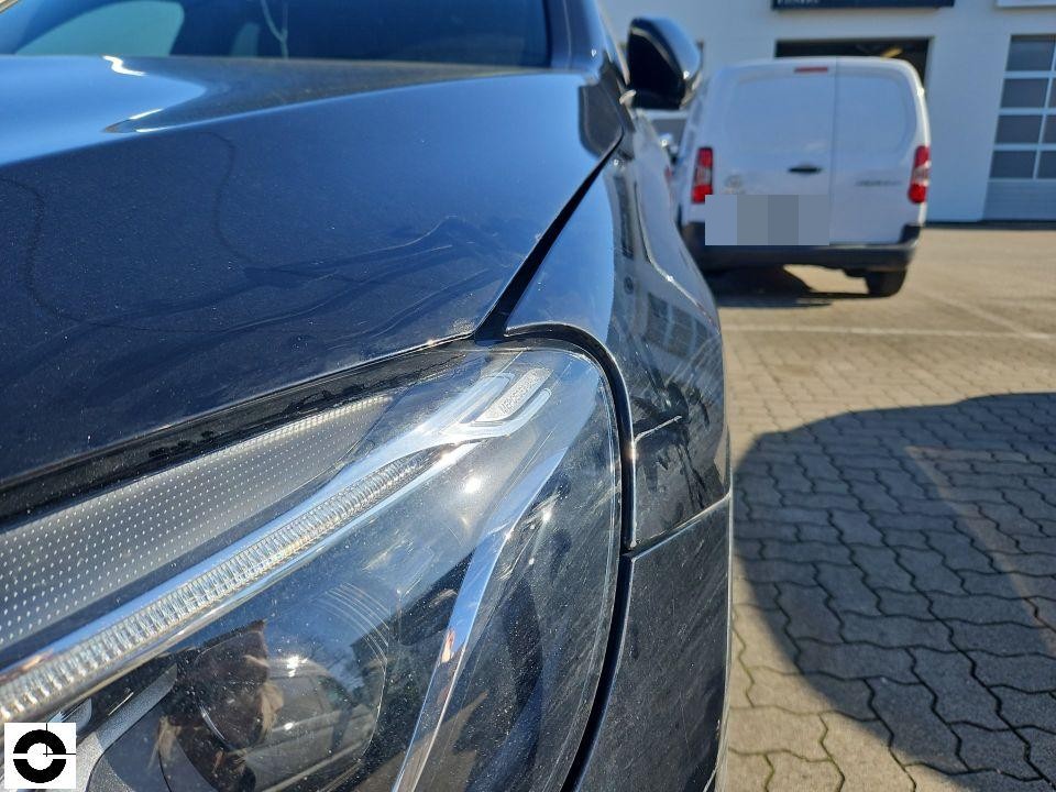 Frontansicht links, Scheinwerfer und Kotflügel, leichte Kratzer auf Motorhaube sichtbar