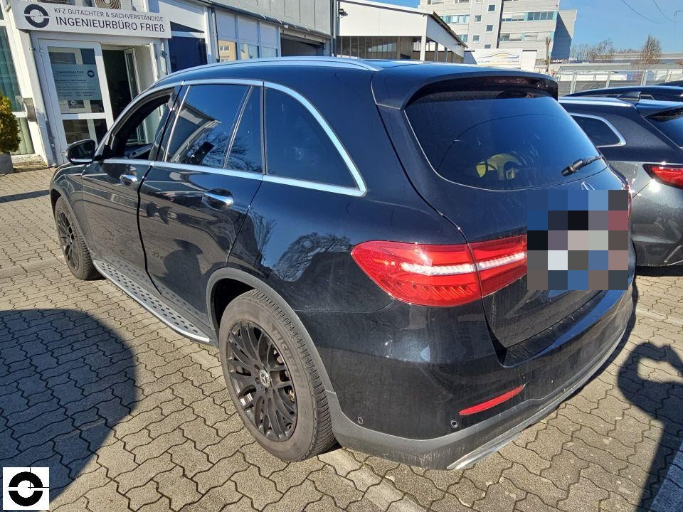 Heckansicht schräg links, dunkelblaues Kombi-Fahrzeug, Kennzeichen bereits pixeliert