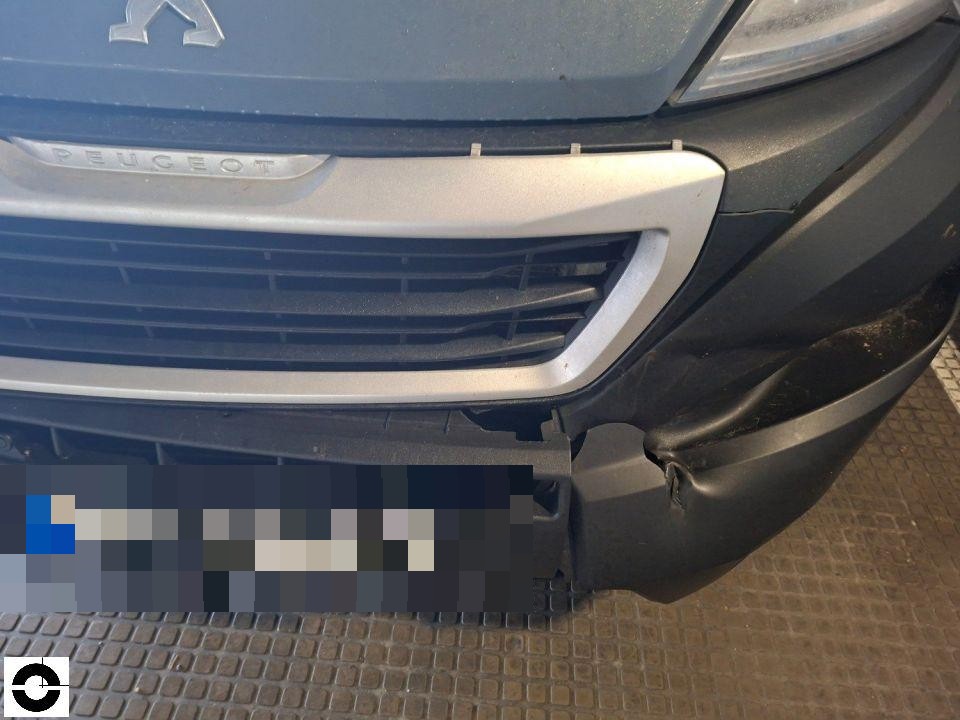 Frontansicht, beschädigte Stoßstange rechts mit Riss und Verformung, Kühlergrill sichtbar