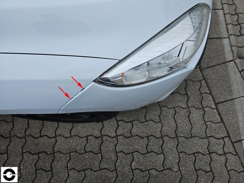 Frontansicht links, Kratzer an Stoßstange und Kotflügel durch rote Pfeile markiert
