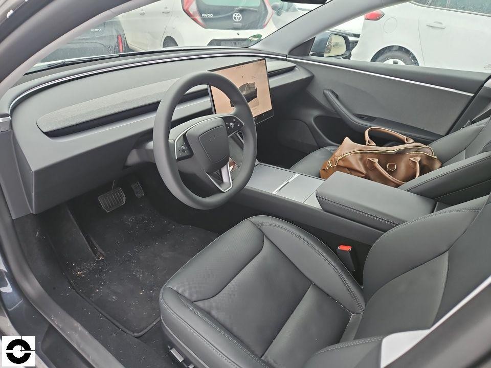 Innenraumansicht von links, Fahrersitz, Lenkrad, Touchscreen-Display, schwarze Ledersitze