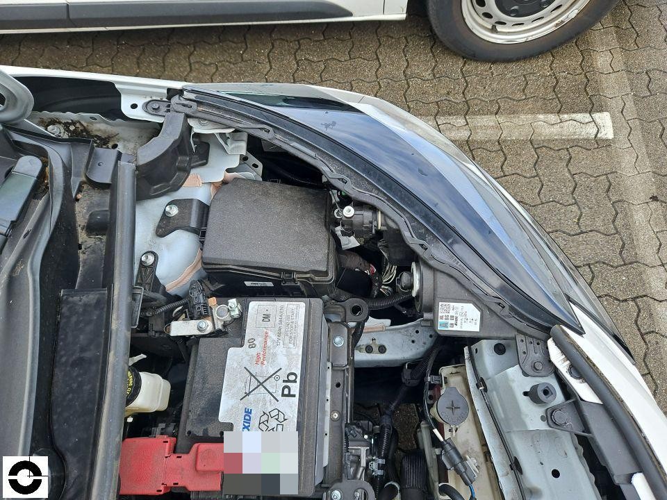 Motorraum mit geöffneter Haube, Blick auf Batterie und Sicherungskasten