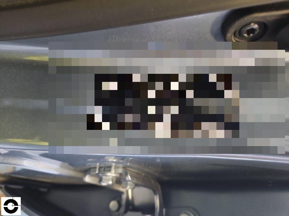 Fahrzeug-Identifikationsnummer (VIN) auf Typenschild im Motorraum, teilweise pixeliert