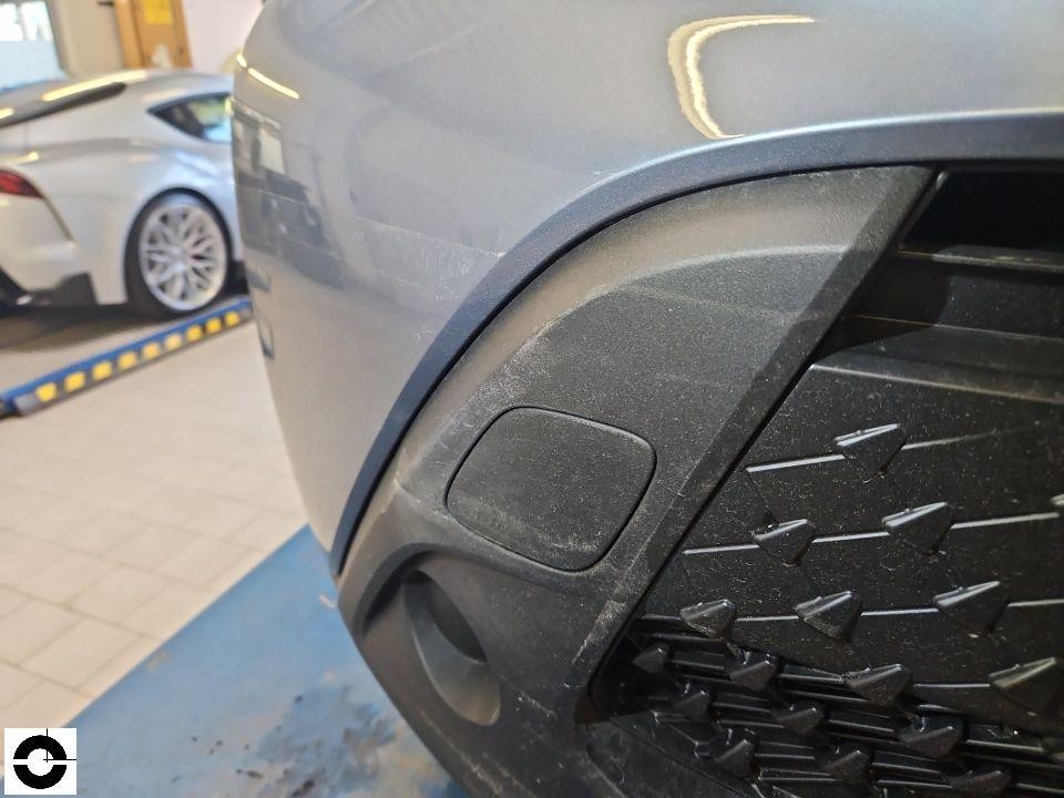 Nahaufnahme vordere Stoßstange rechts mit Kühlergrill, leichte Verschmutzung sichtbar