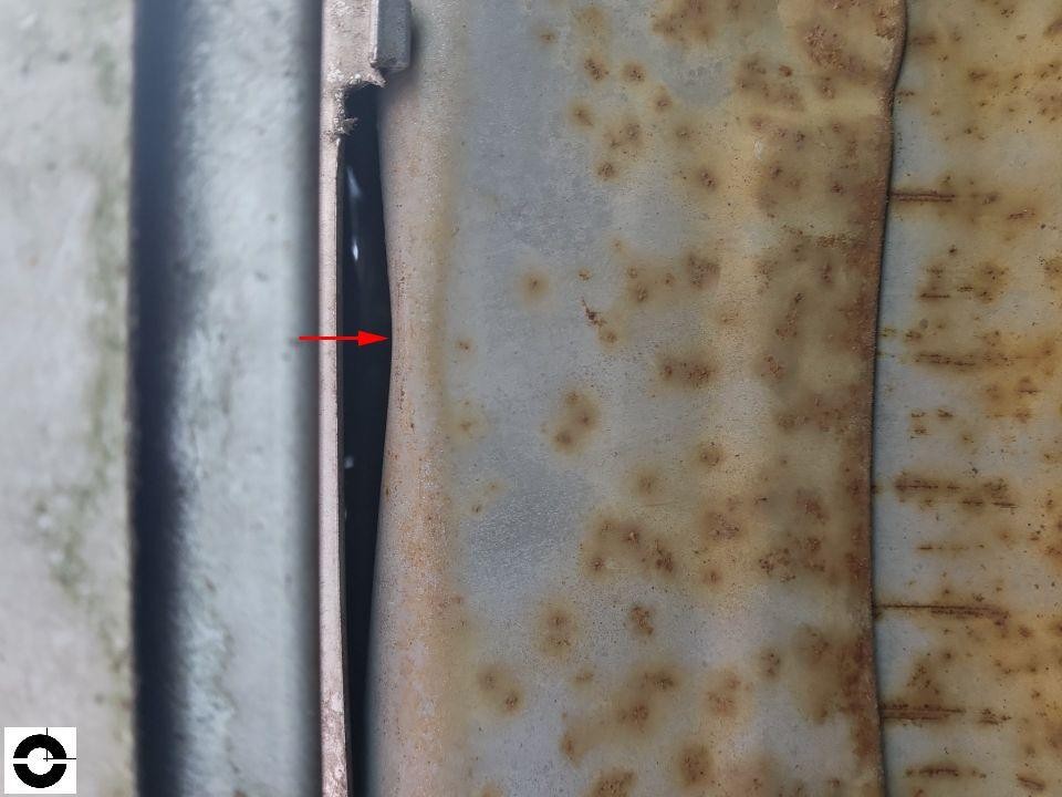 Detailaufnahme Schweller/Karosseriefalz mit starker Rostbildung und rotem Pfeil als Markierung