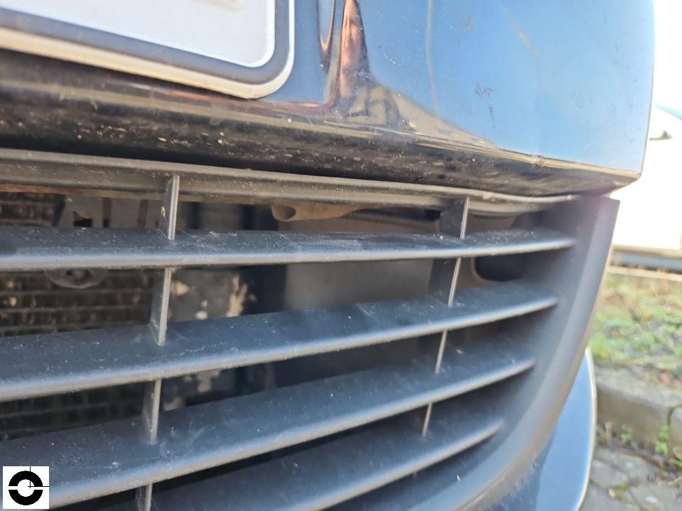 Nahaufnahme Frontgrill mit Beschädigung, Chromleiste verbogen, Kühlergrill verschmutzt