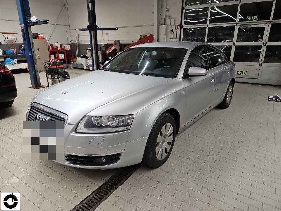 Frontansicht schräg rechts in Werkstatt, silberner Audi, Kennzeichen pixeliert