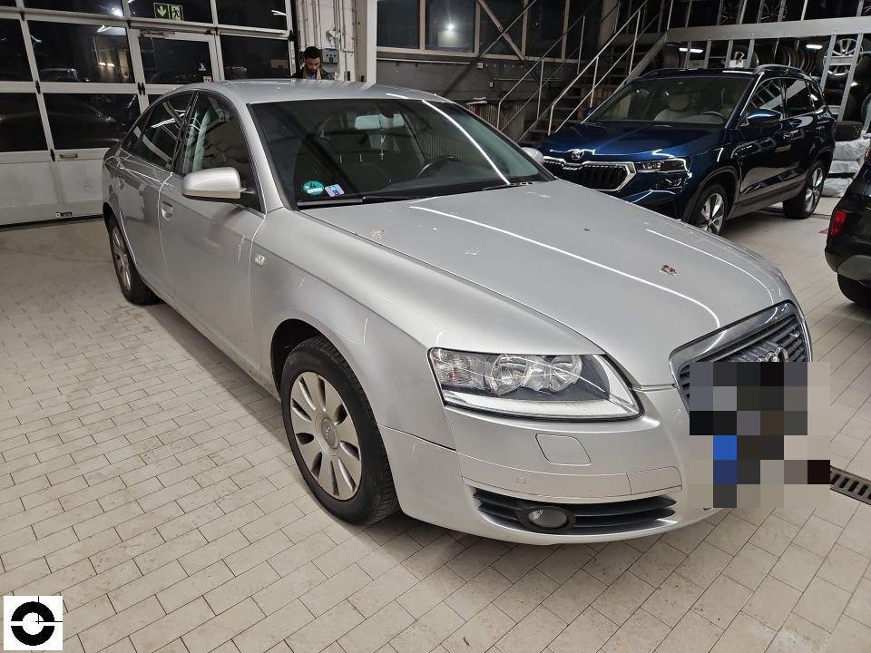 Frontansicht schräg von rechts, silbernes Fahrzeug in Werkstatthalle, keine sichtbaren Schäden