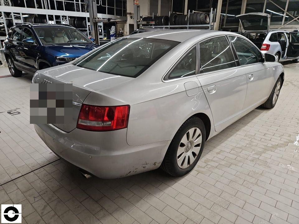 Heckansicht schräg rechts, silberne Limousine in Werkstatthalle, Verschmutzung am Heck