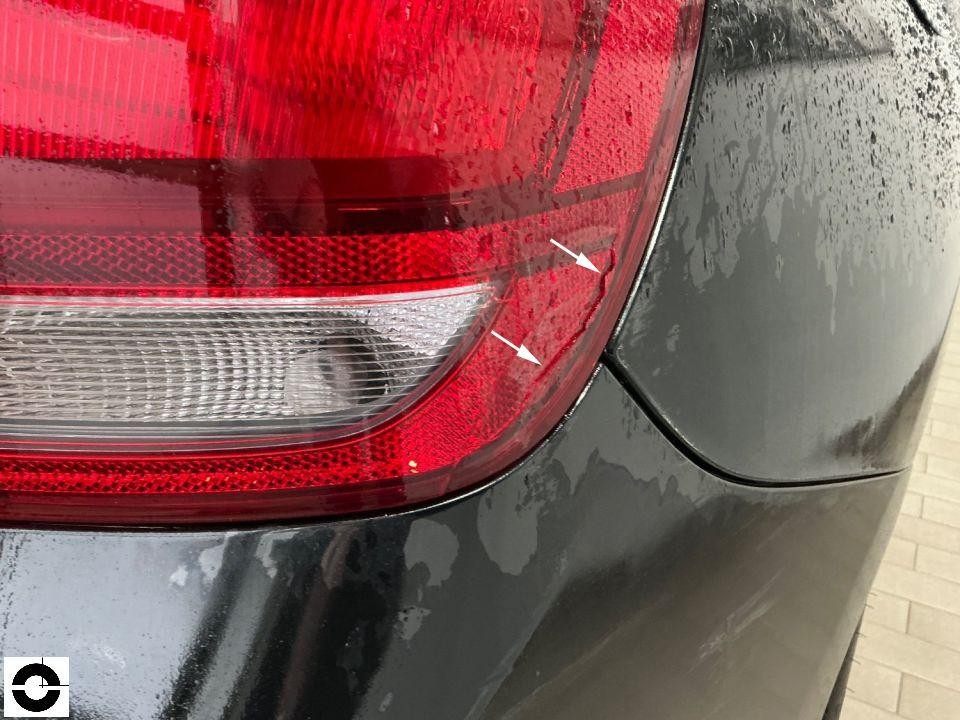 Heckansicht links, Kratzer an Stoßstange neben Rückleuchte markiert mit Pfeilen