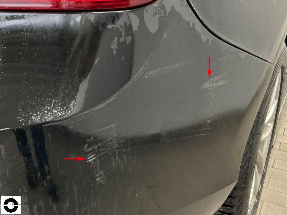 Hintere Stoßstange links, Kratzer und Schürfspuren mit roten Markierungspfeilen