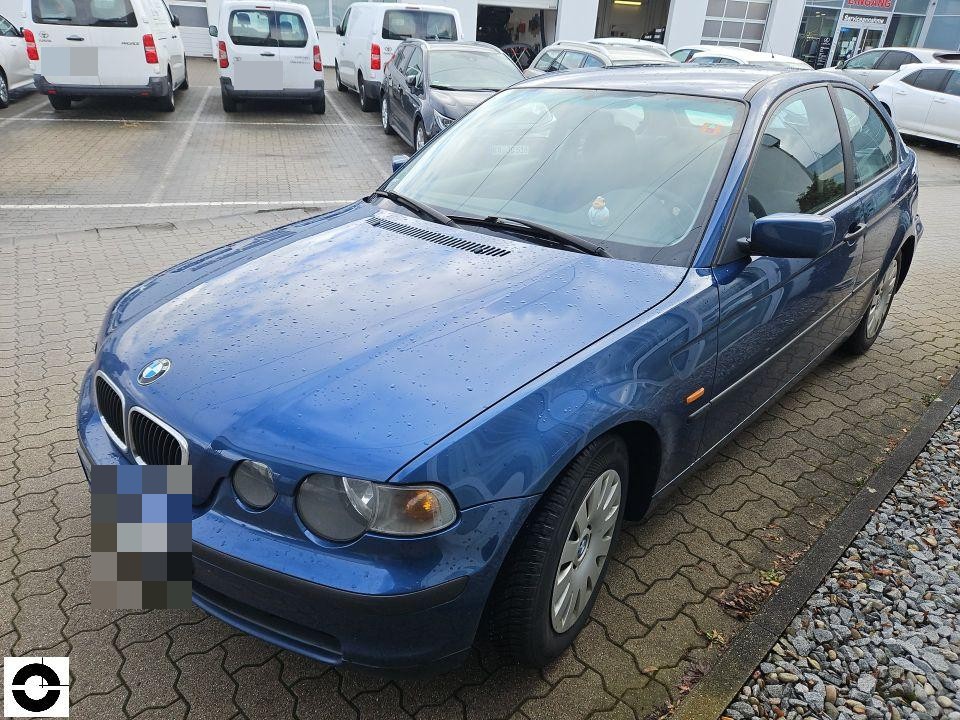 Frontansicht schräg rechts, blaues Fahrzeug auf Parkplatz, Regentropfen auf Motorhaube