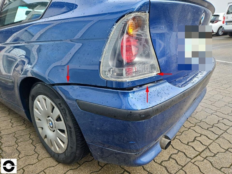 Heckansicht links, rote Pfeile markieren Schäden an Stoßstange und Rückleuchte