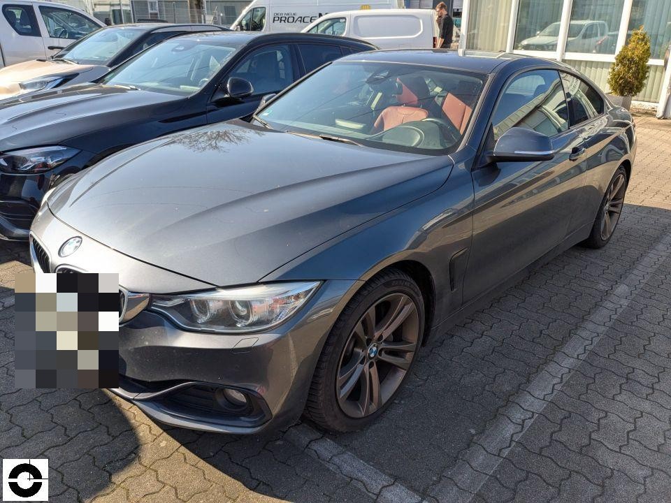 Frontansicht schräg rechts, grau-metallic Coupé, keine sichtbaren Schäden, Parkplatz