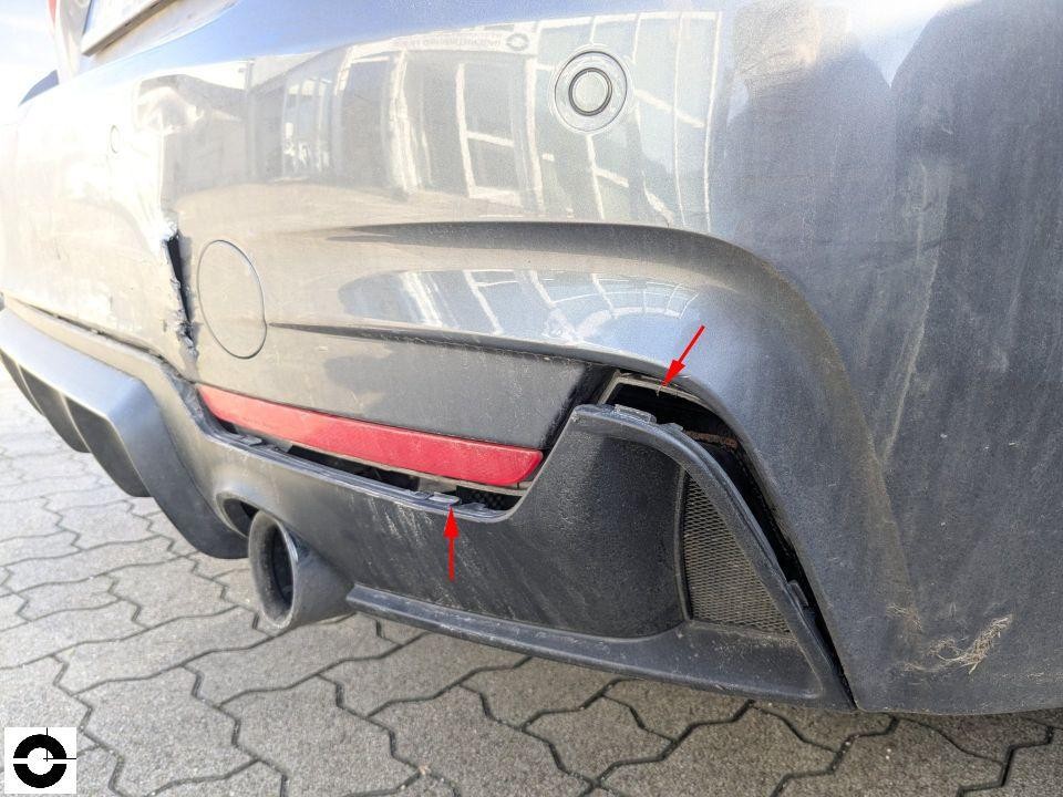 Hintere Stoßstange links mit Riss und Beschädigung, rote Pfeile markieren Schaden