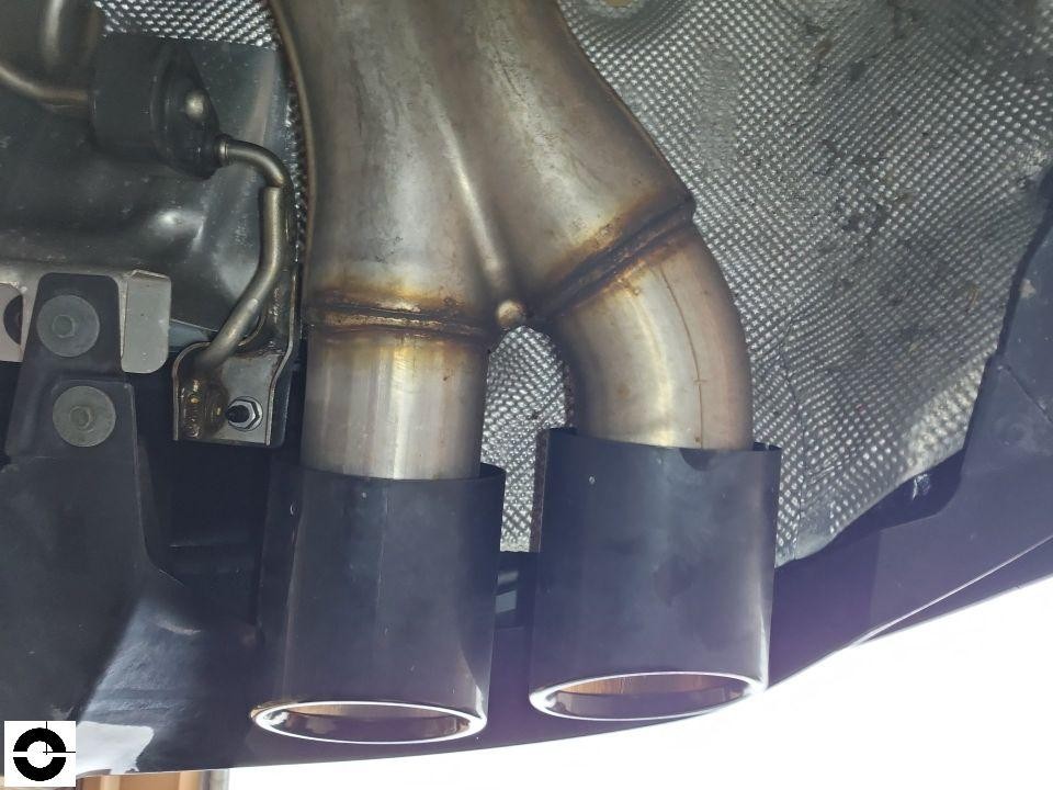 Detailaufnahme Auspuffanlage mit zwei Endrohren und Hitzeschutzblech von unten