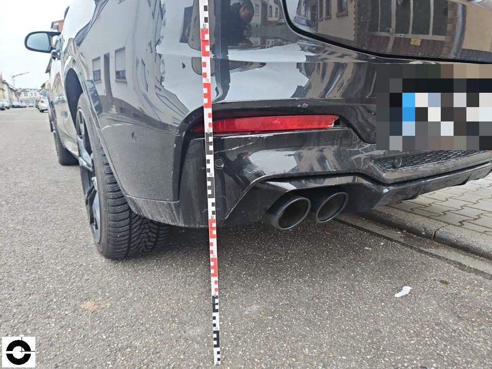 Heckansicht links mit Messlatte, Stoßfänger und Auspuffanlage, leichte Kratzer sichtbar