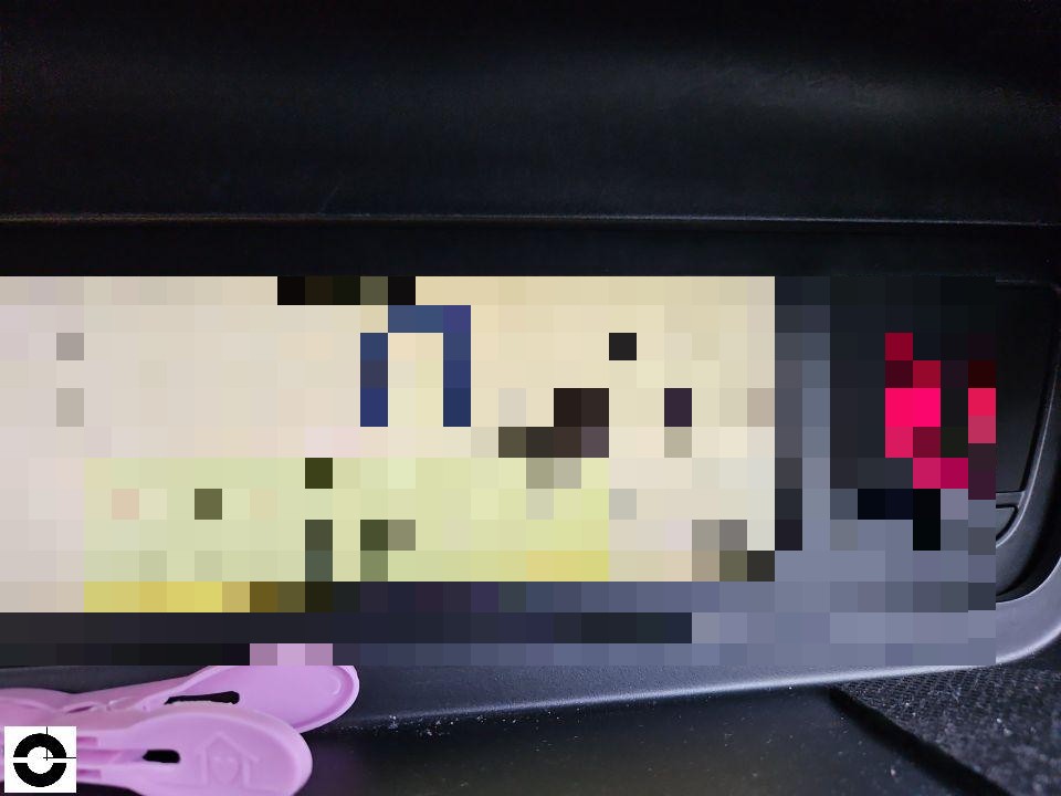 Geöffnetes Handschuhfach mit Dokumenten und rosa Wäscheklammern im Innenraum