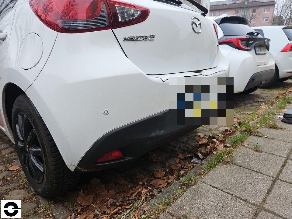 Heckansicht schräg links, Schaden an hinterer Stoßstange rechts mit Lackabplatzung