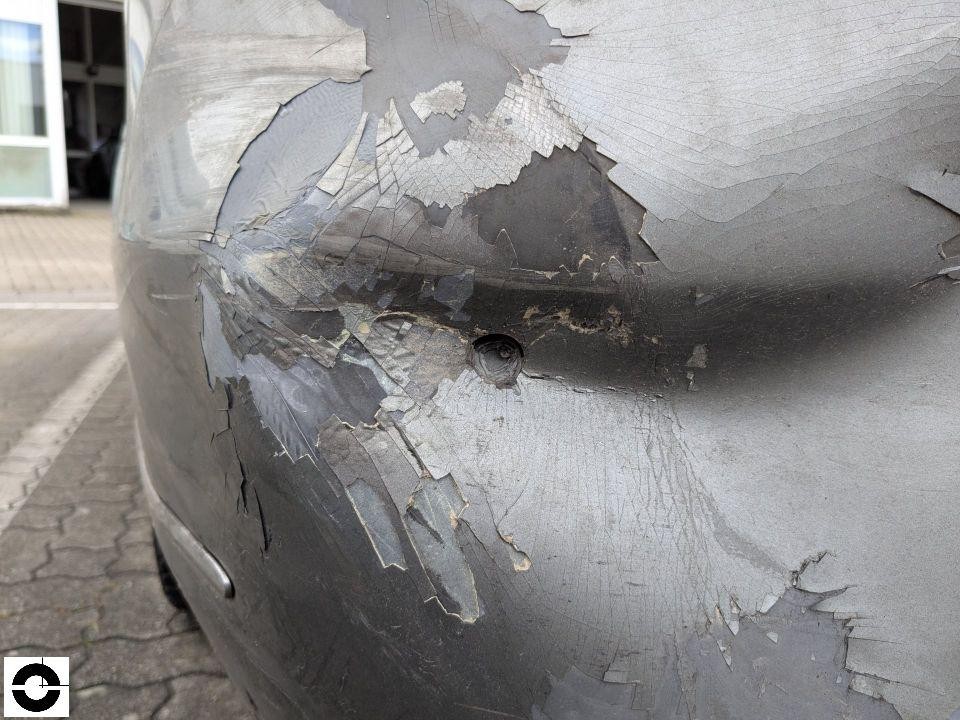 Detailaufnahme Motorhaube mit großflächigem Lackschaden und Abblätterungen