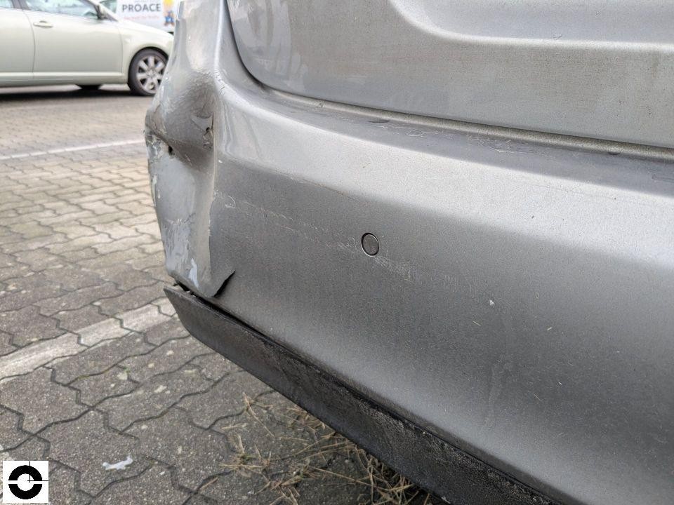 Hintere Stoßstange links mit Delle, Kratzern und abgeplatztem Lack