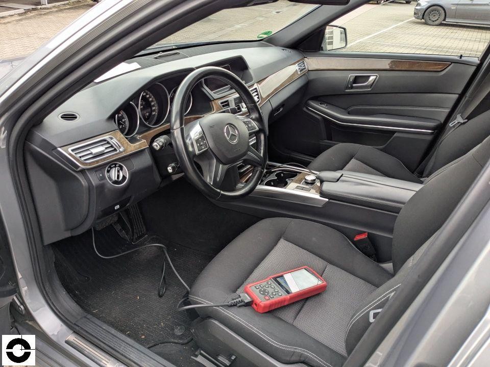 Innenraum Fahrerseite mit Diagnosegerät auf Beifahrersitz, schwarze Lederausstattung