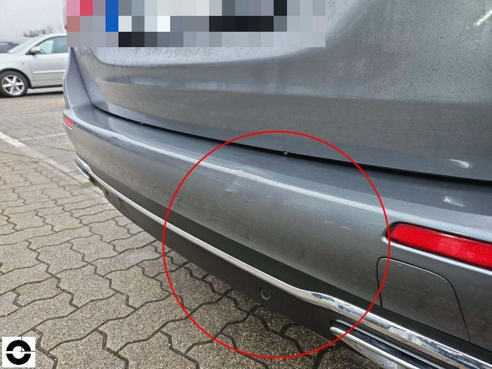 Heckansicht, roter Kreis markiert Kratzer und Schürfspuren an hinterer Stoßstange rechts