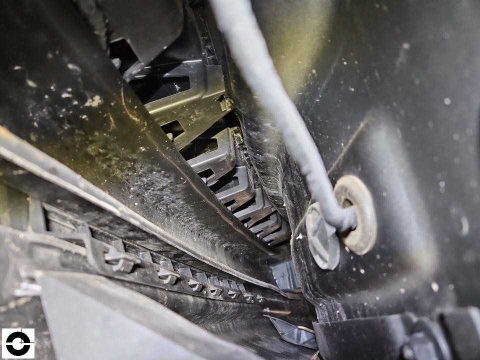 Detailaufnahme Motorraum, Kühlerbereich mit Lüfterlamellen und Kabeln, verschmutzt