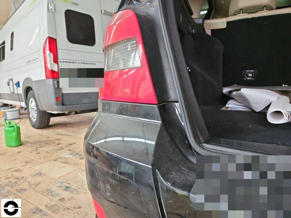 Heckansicht links mit geöffneter Heckklappe, Rückleuchte und hintere Stoßstange sichtbar