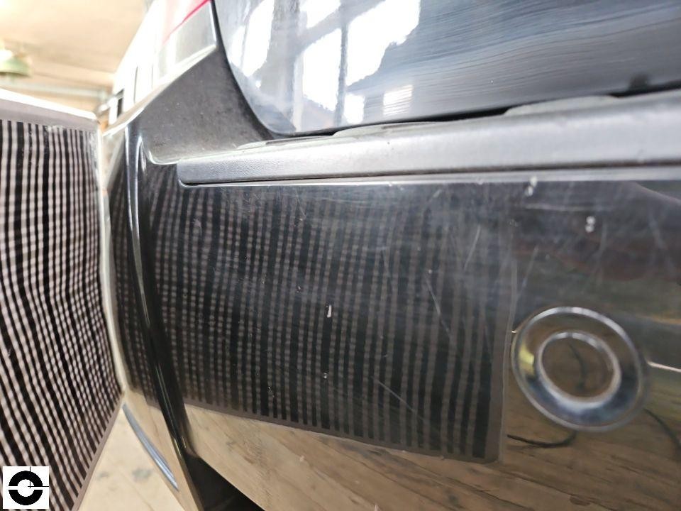 Heckbereich mit Stoßstange, Kratzer und Lackschäden sichtbar, Parksensor erkennbar