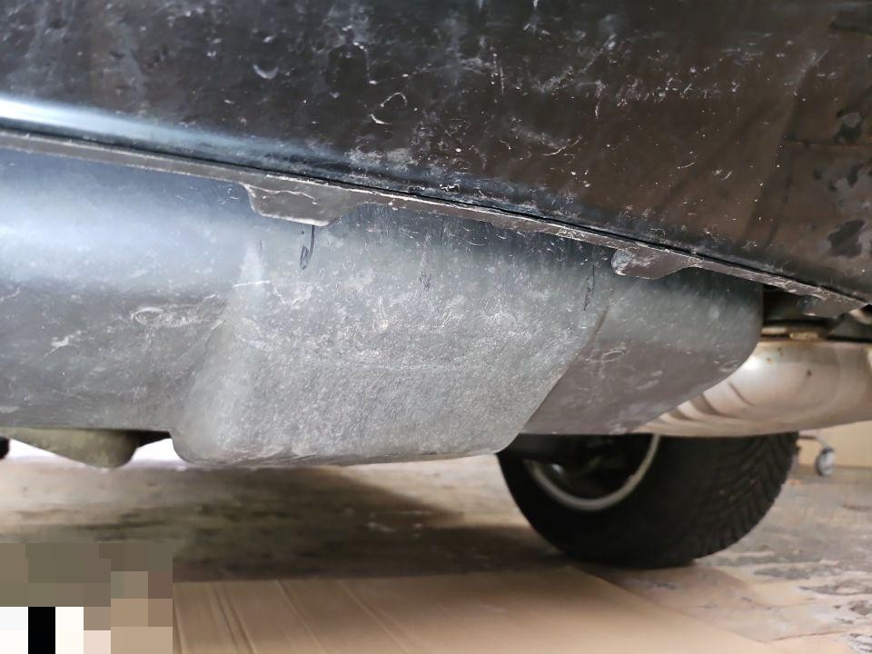 Heckschürze mit starken Kratzspuren und Verschmutzungen, Ansicht von unten links