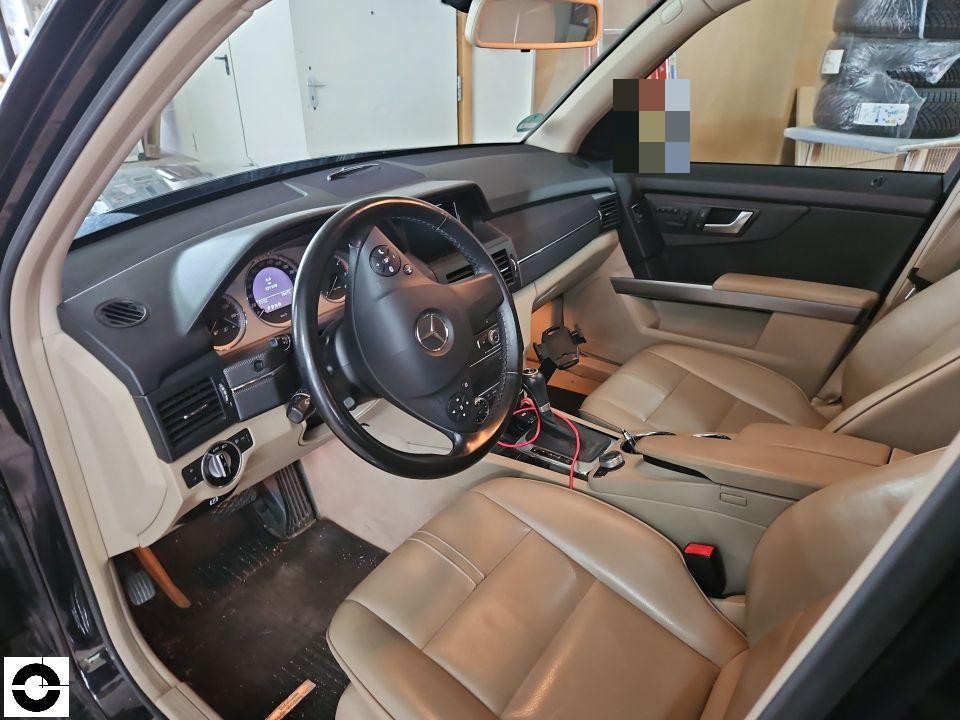 Innenraum, Blick durch geöffnete Fahrertür, beige Lederausstattung, Armaturenbrett und Lenkrad sichtbar