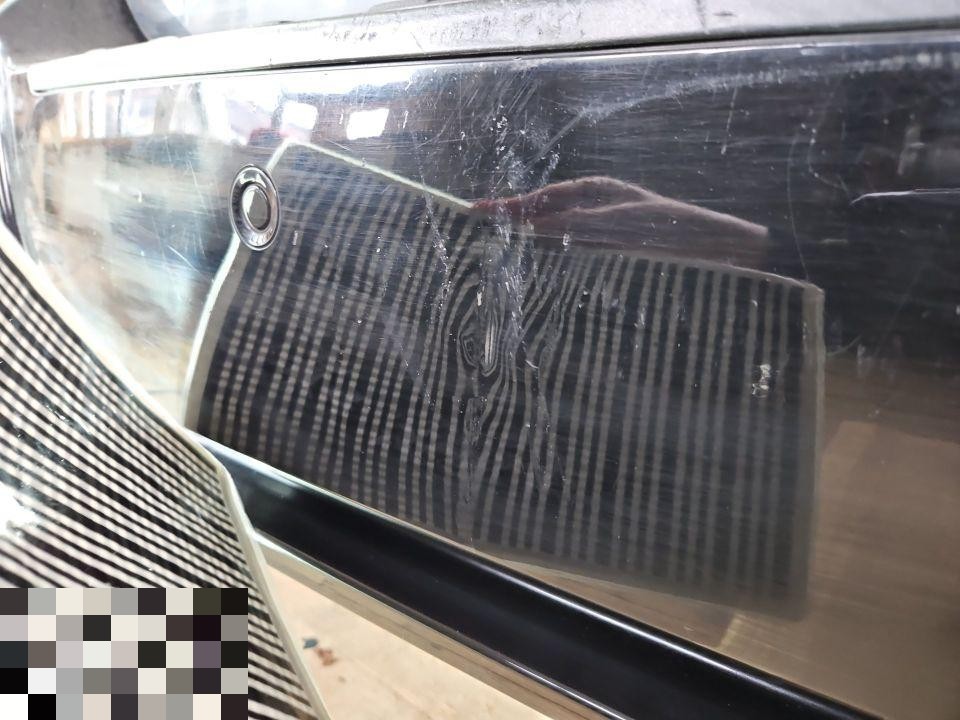 Nahaufnahme Heckscheibe mit Dellenreflexion, Kratzer und Beschädigungen sichtbar