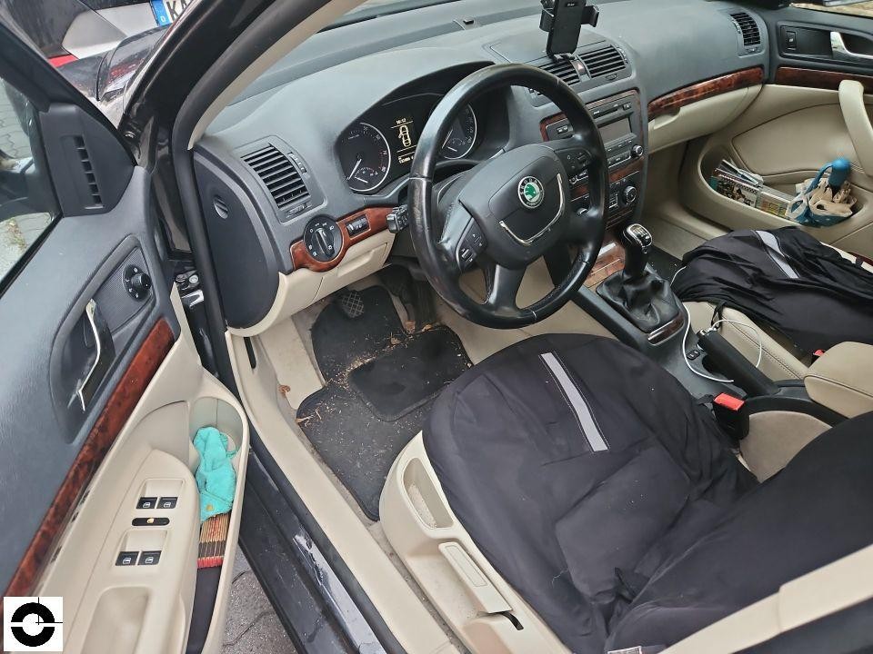 Innenraum Fahrerseite, geöffnete Tür, beige-schwarze Ausstattung mit Holzdekor, verschmutzter Fußraum