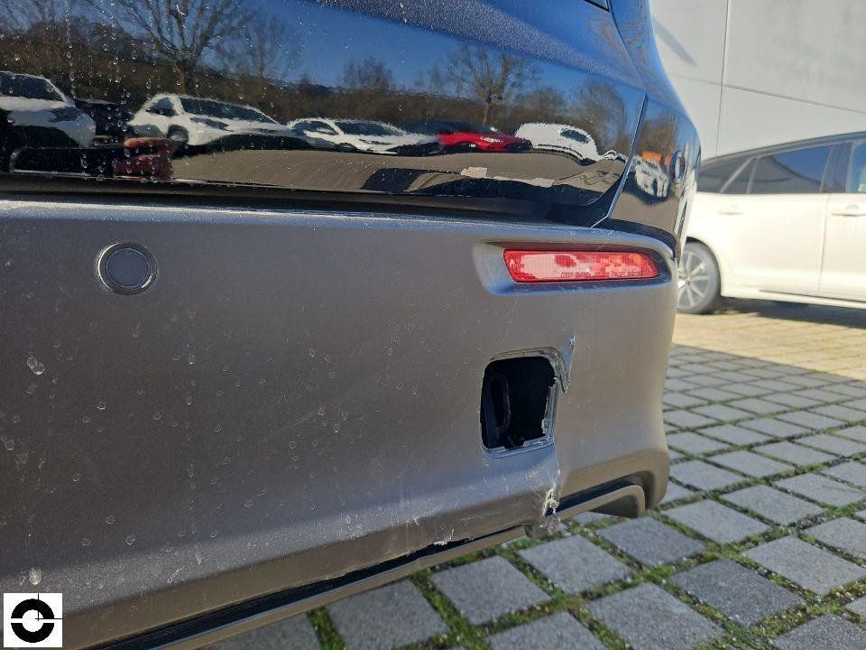 Heckansicht, hintere Stoßstange mit fehlendem Anhängerkupplungsdeckel, Kratzer und Beschädigungen