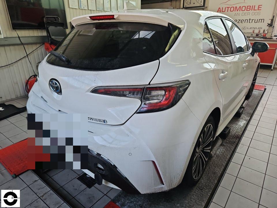 Heckansicht in Werkstatt, Stoßstange hinten links beschädigt und verschmutzt