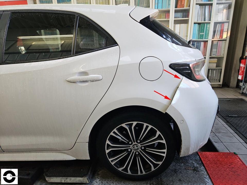 Heckansicht links, Schaden am hinteren Kotflügel und Stoßstange mit roten Markierungspfeilen