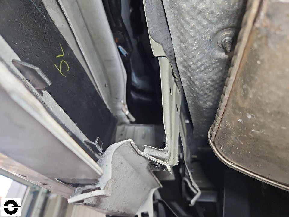 Unterboden-Ansicht, deformierte Schwellerverkleidung und Bodenblech, Blick auf Katalysator rechts