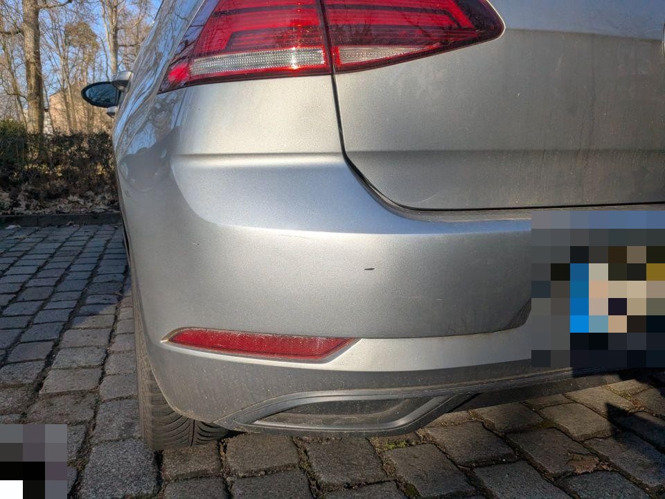 Heckansicht links, hintere Stoßstange mit leichten Kratzern und Verschmutzungen