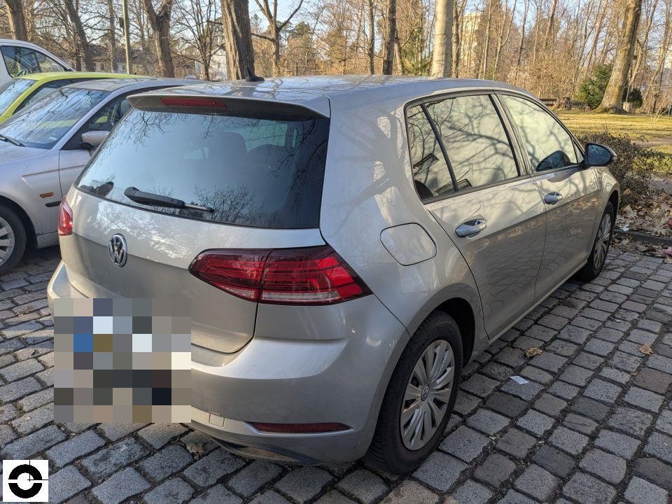 Heckansicht schräg rechts, silbernes Fahrzeug auf Kopfsteinpflaster, Kennzeichen pixeliert