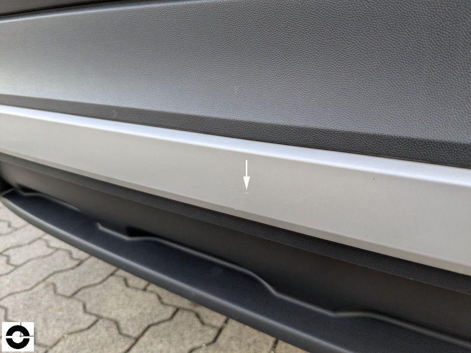 Detailaufnahme hintere Stoßstange mit Pfeilmarkierung auf kleinen Kratzer, silber/grau